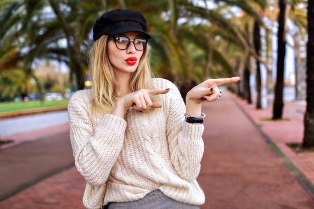 Young woman pointing both fingers to the side