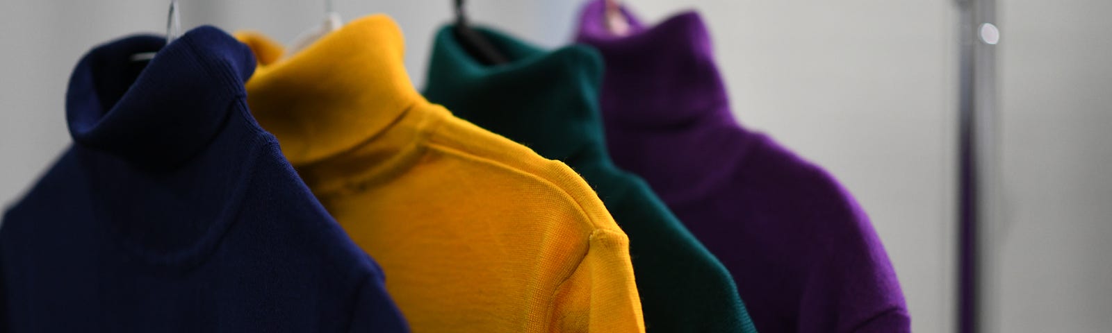 A hanger with various colored turtlenecks