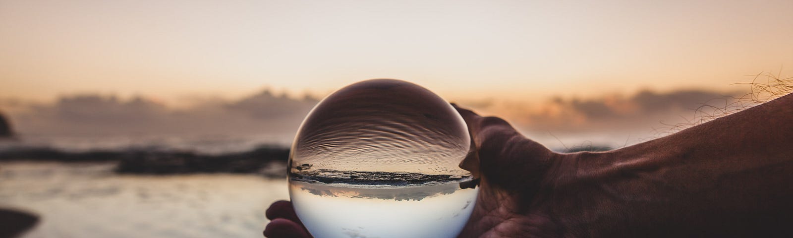 Photo by Photoholgic; photo of man holding crystal ball posted on James Goydos MD’s article re prediction of COVID-19 outcomes