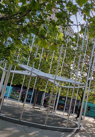 A large art installation in the shape of a bird cage, outside of Kings Cross train station in London, UK