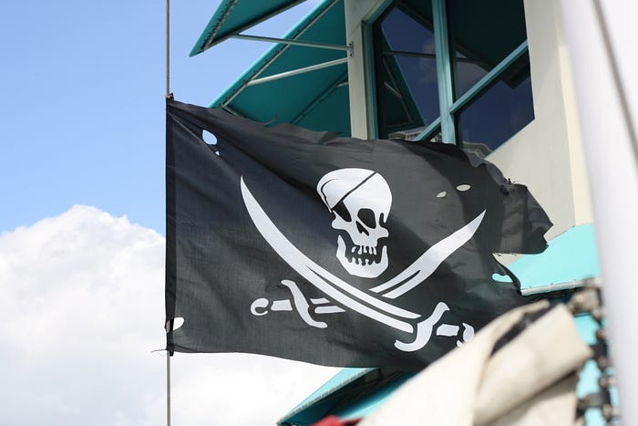 The Jolly Roger flying from the wheelhouse of large boat.