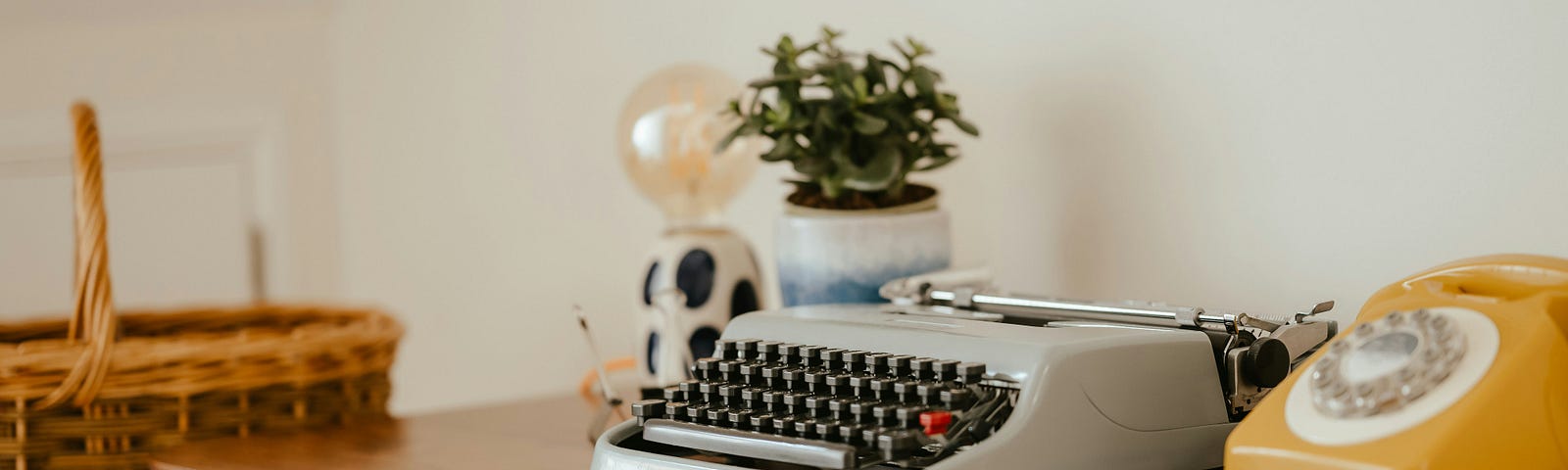 A typewrter and an old dial-up telephone on a writing desk.