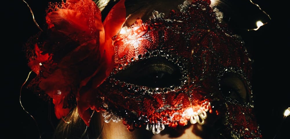 Woman wearing red carnival mask.