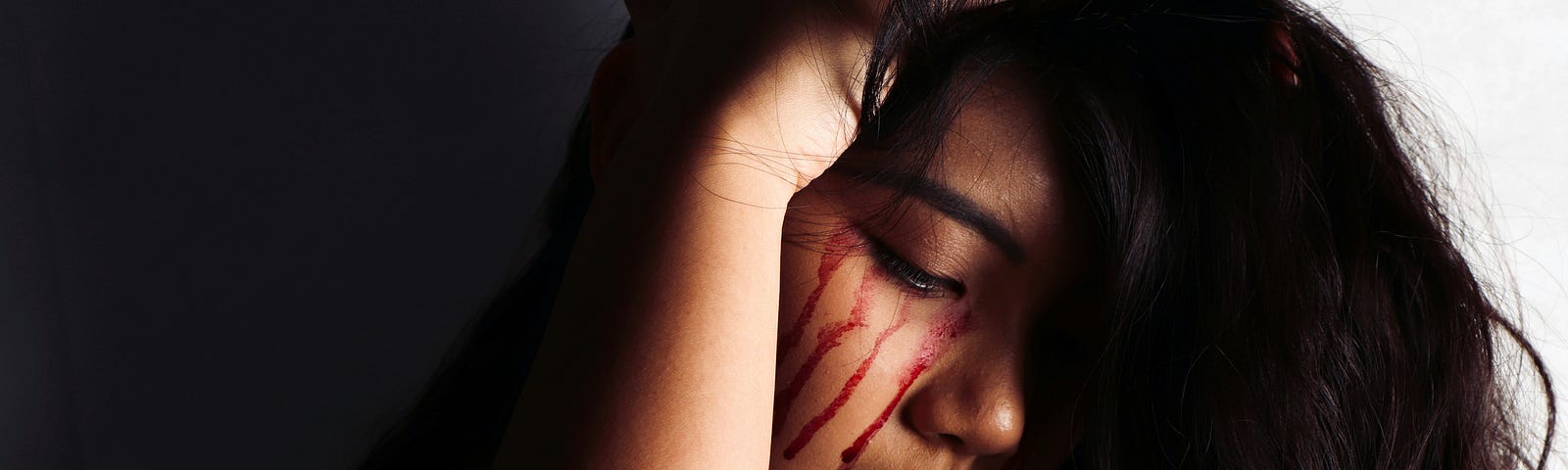 Beautiful young woman weeping bloody tears