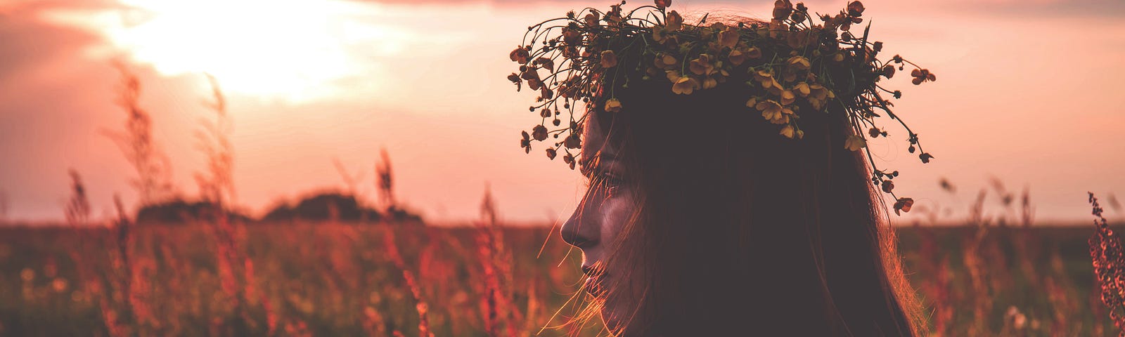 Lone girl wearing a flower crown in a field of flowers