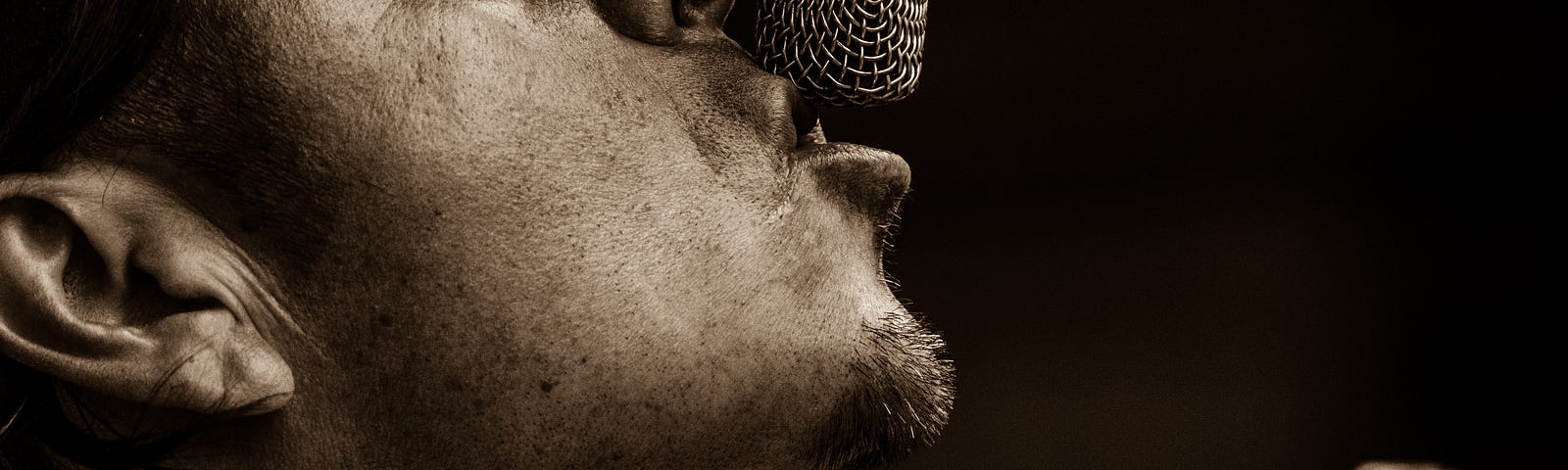 A close up shot of a musician singing into a microphone