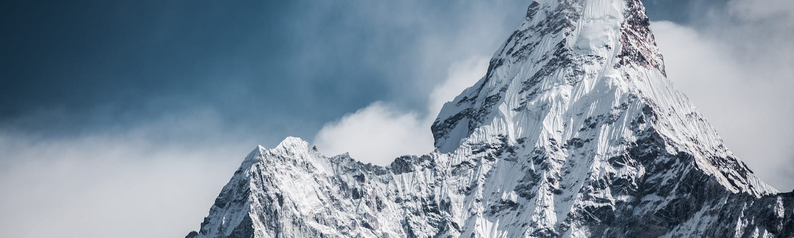 Bluish image of the summit of mountain Everest, covered in snow.