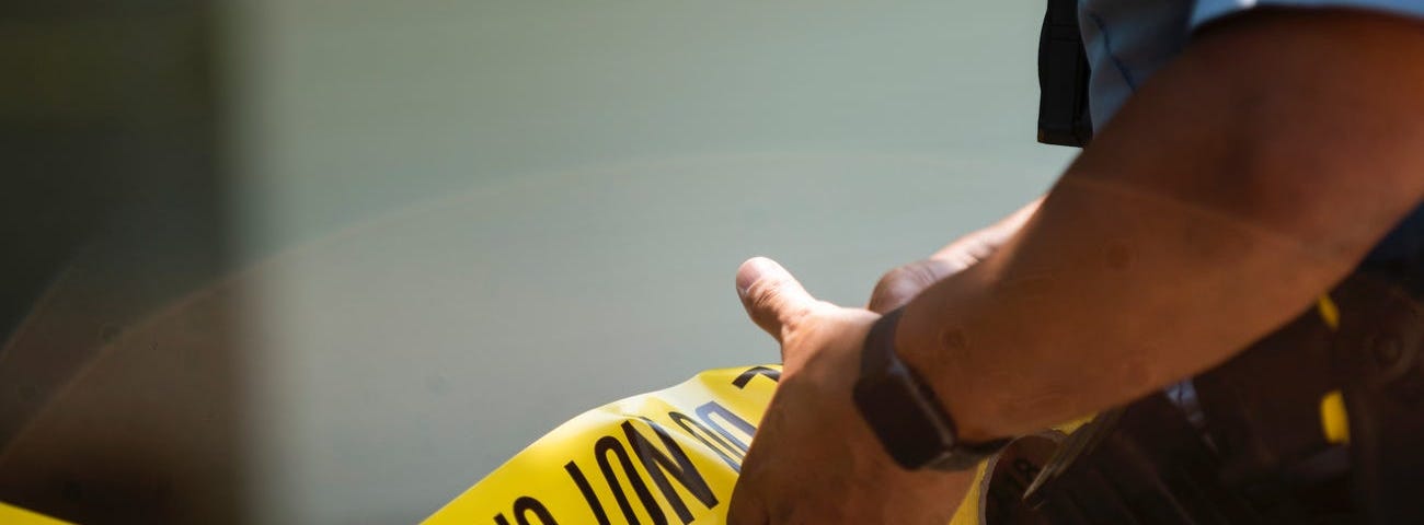 A Minneapolis Police officer unrolls caution tape at a crime scene on June 16, 2020 in Minneapolis, Minnesota.