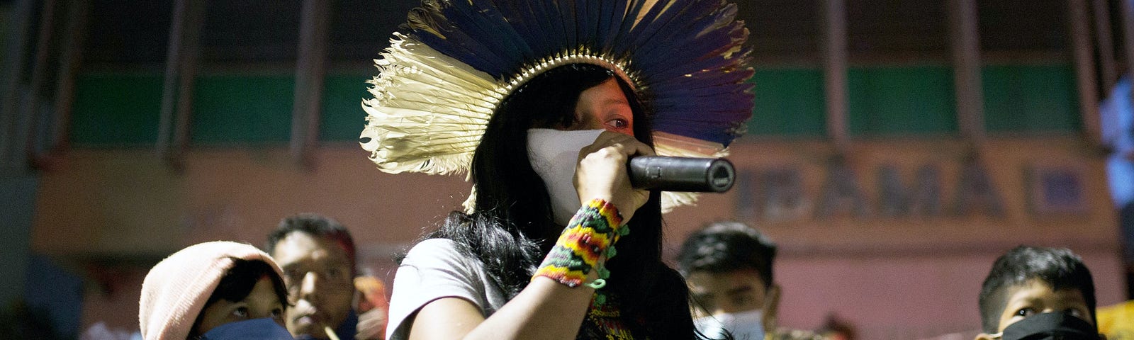 A climate activist holds a microphone among a crowd