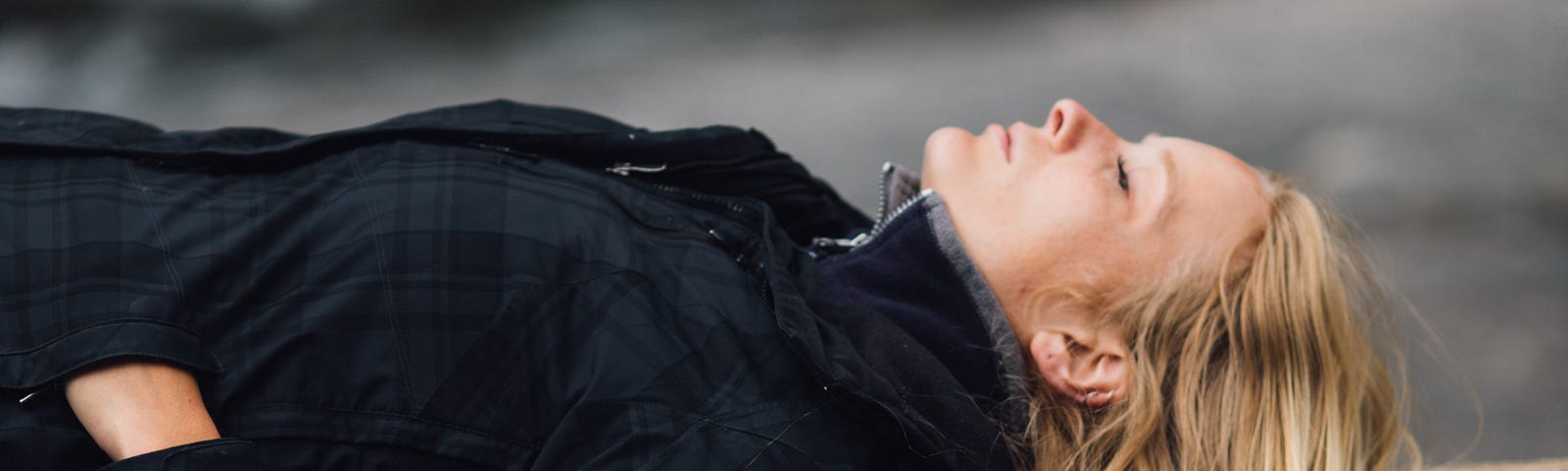 Here is a picture of a young woman lying on a log, eyes closed, reflecting, symbolizing our need to evaluate our relationship with God.