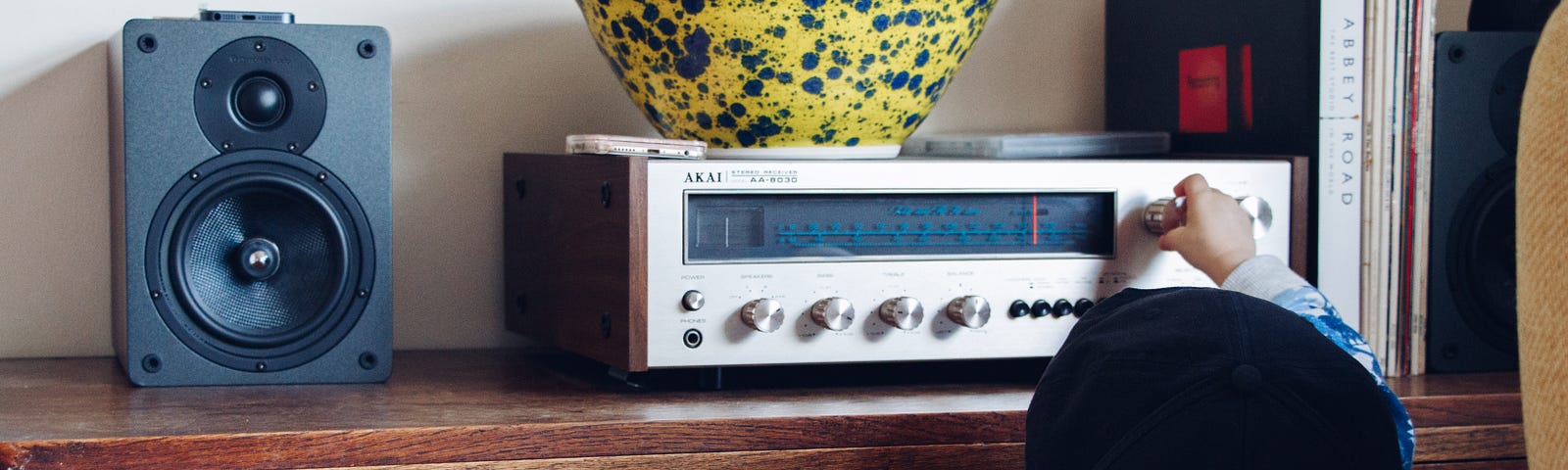 A kid adjusting the volume on a stereo.