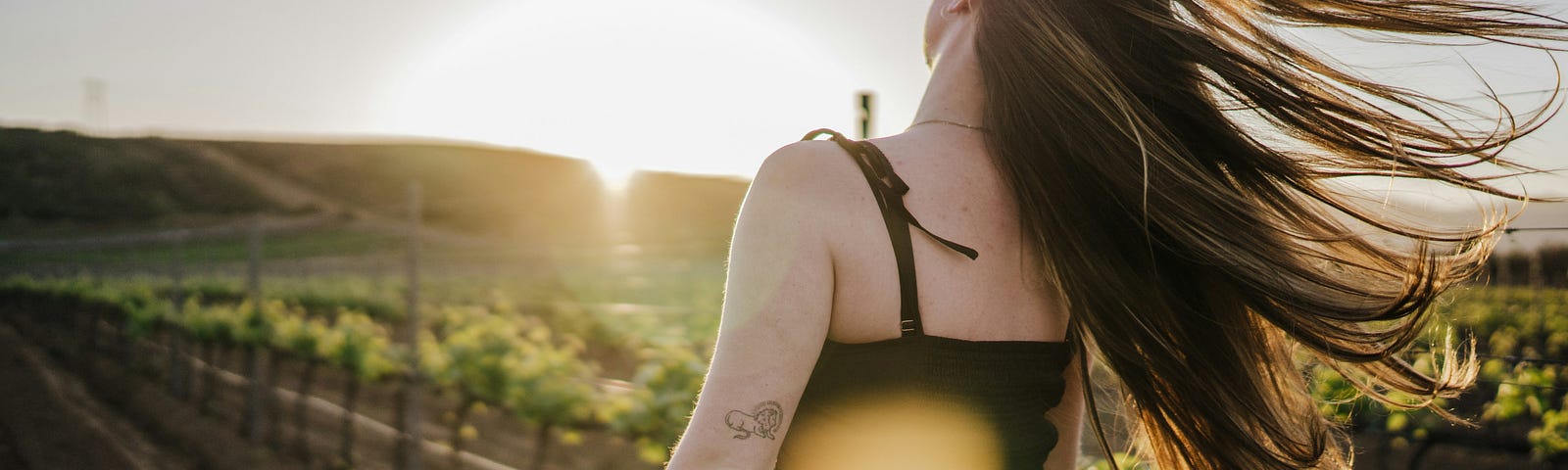 Woman on the side of a country road in reflection as she enjoys a sunny day