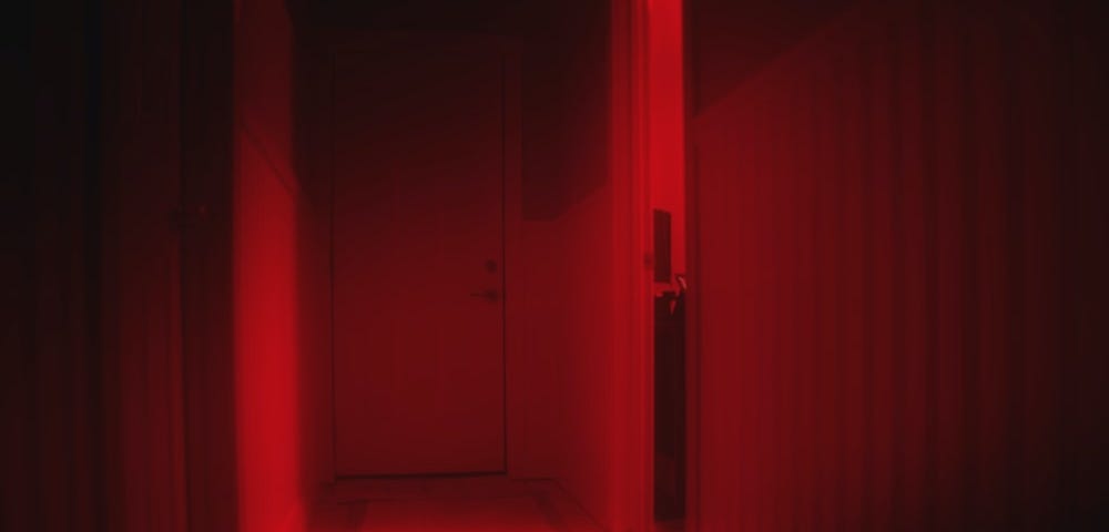 Dark corridor in dim red light.