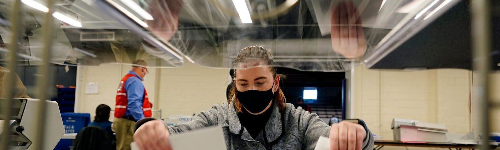 Election worker Kristina Sladek opens mail-in and absentee ballots for the 2020 General Election in West Chester, Pa.