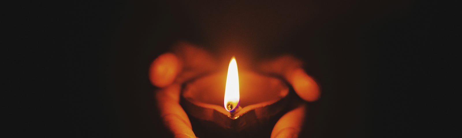 picture of burning candle held in a person’s hands