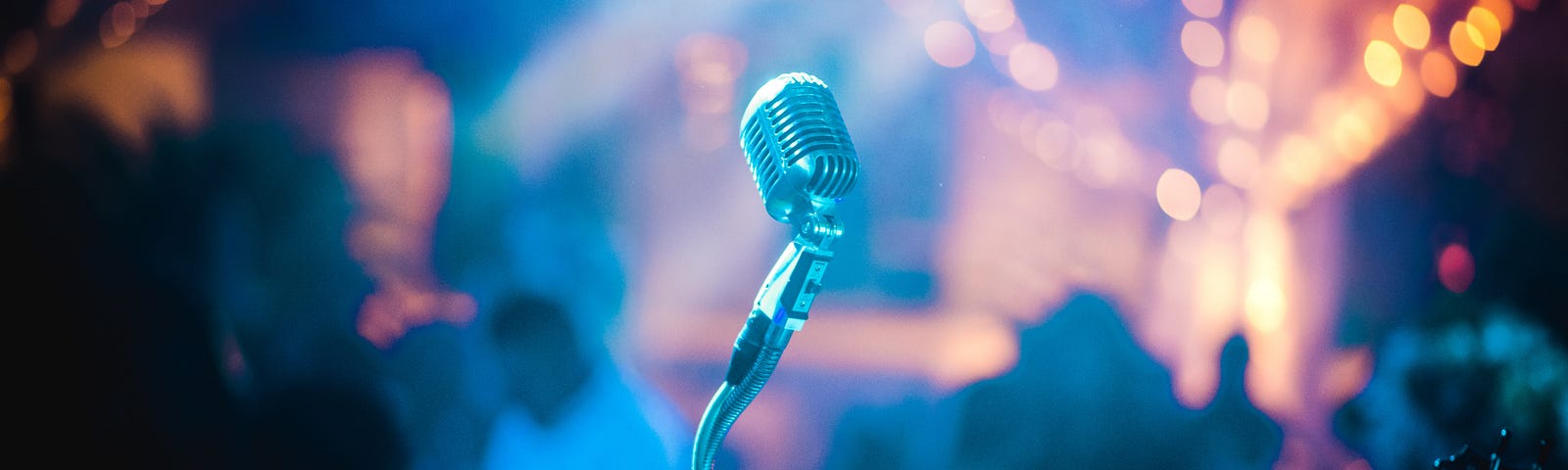 A microphone stand against a blurred show venue background