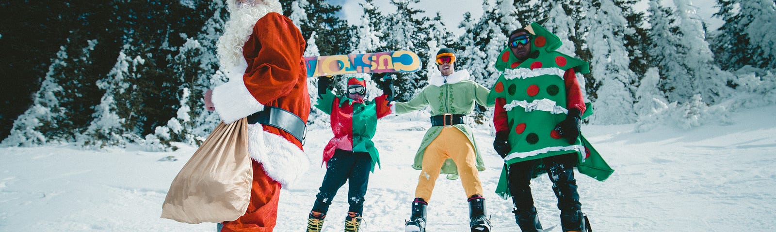 Someone wearing in a Santa suit is skiing and carrying light brown bag.