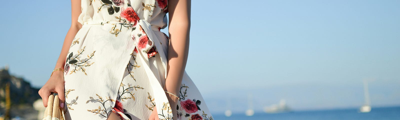 a woman clad in a summer dress on a beach