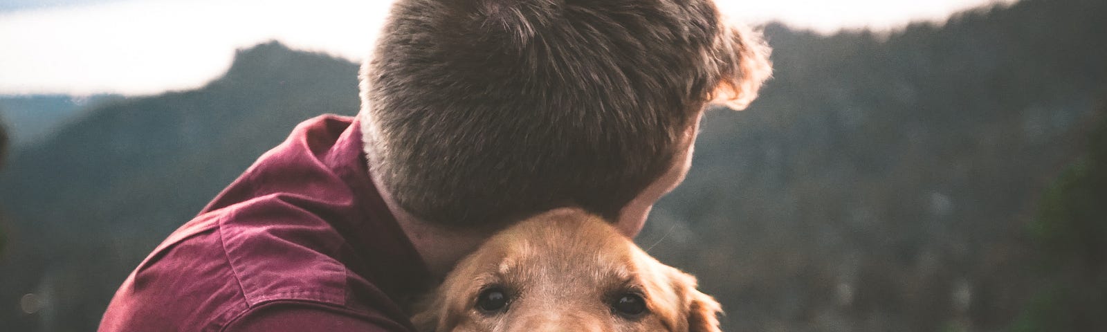 A man hugging his dog.