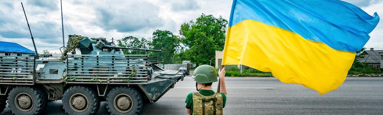 A boy waves a Ukrainian flag as an armored vehicle from the Ukrainian army goes to the Bakhmut frontlines, in Sloviansk, Ukraine, June 27, 2023. Photo by Celestino Arce/NurPhoto/Reuters