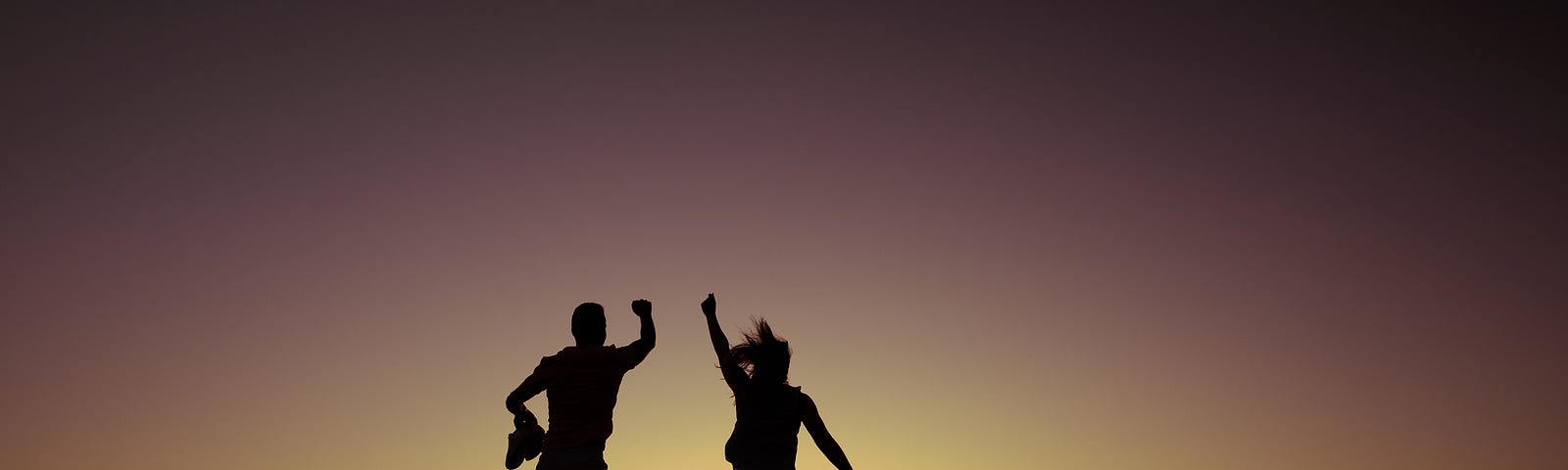 A man and a woman jumping with happiness
