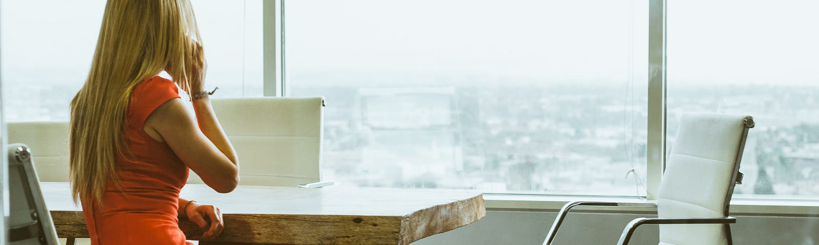 Woman is taking a call in the office. Next she will go ahead to write an important email to share her thoughts with her employees