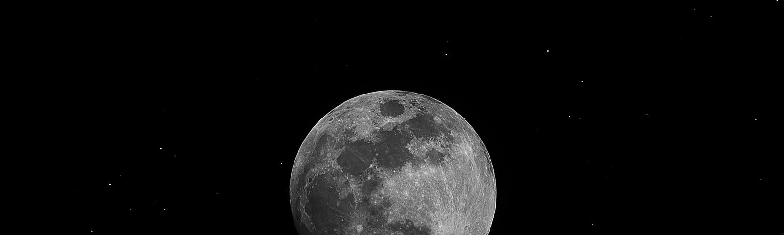 A full moon in the centre of a dark sky