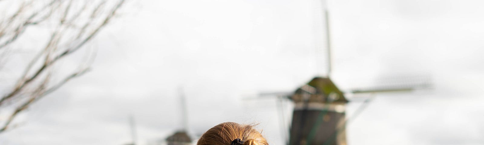 A woman looking at the windmills and a canal