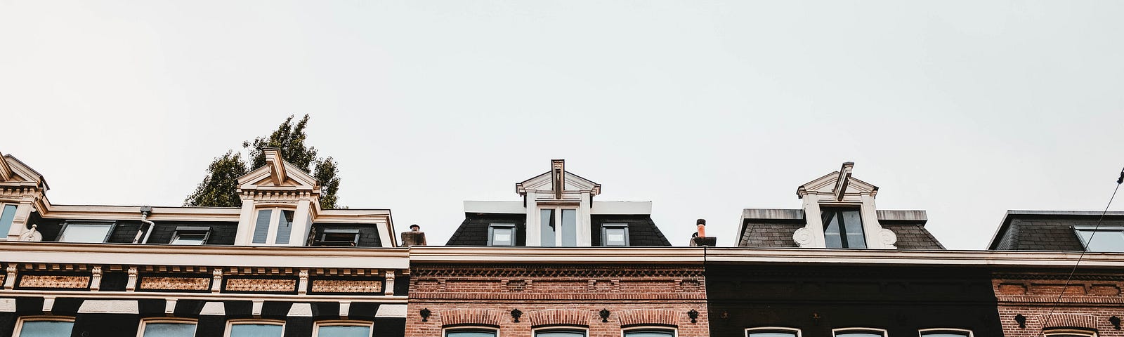 An image of terraced houses, some with black facades, others brown.