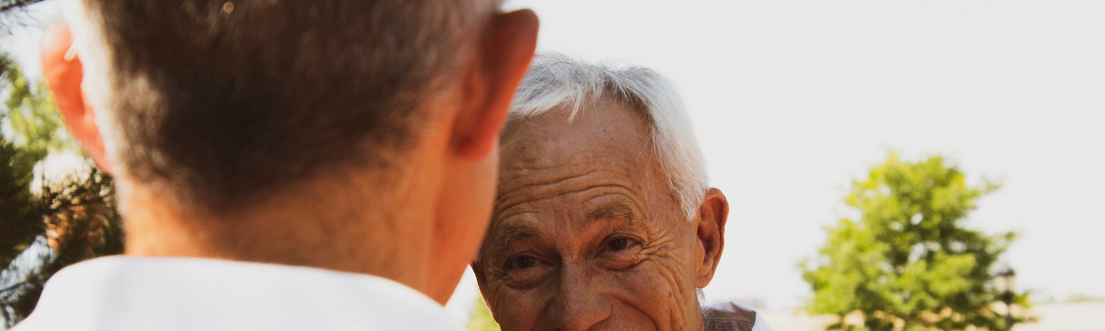 Younger man in foreground conversing with laughing older man