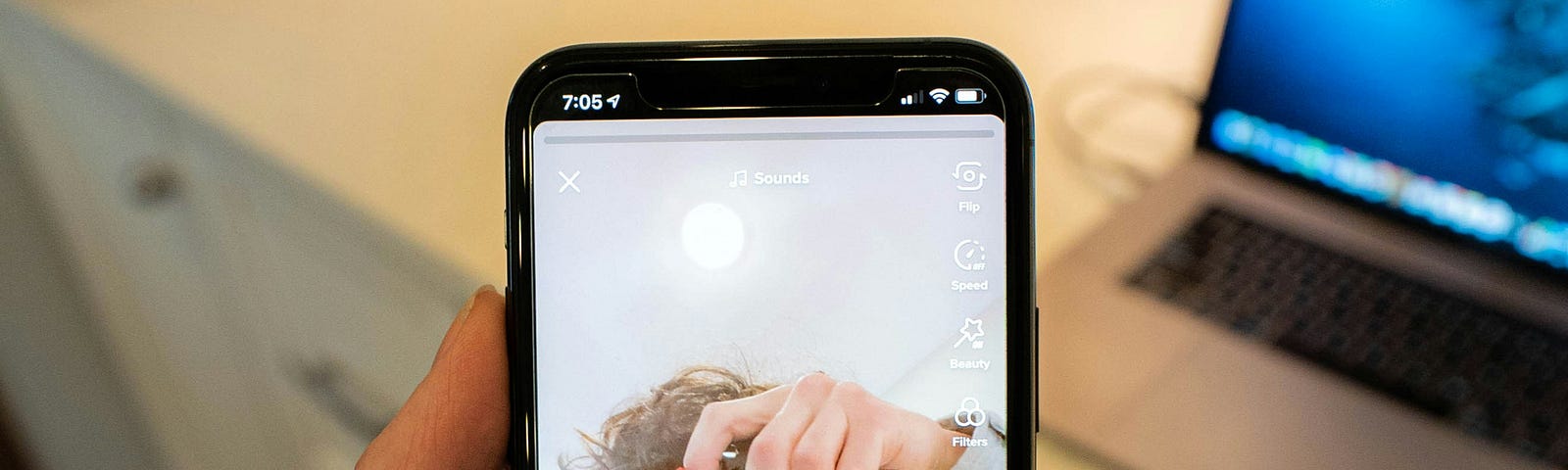 a person holding a phone in their hand- on the display you can see someone else holding a camera and taking a picture- the lense covers the face.