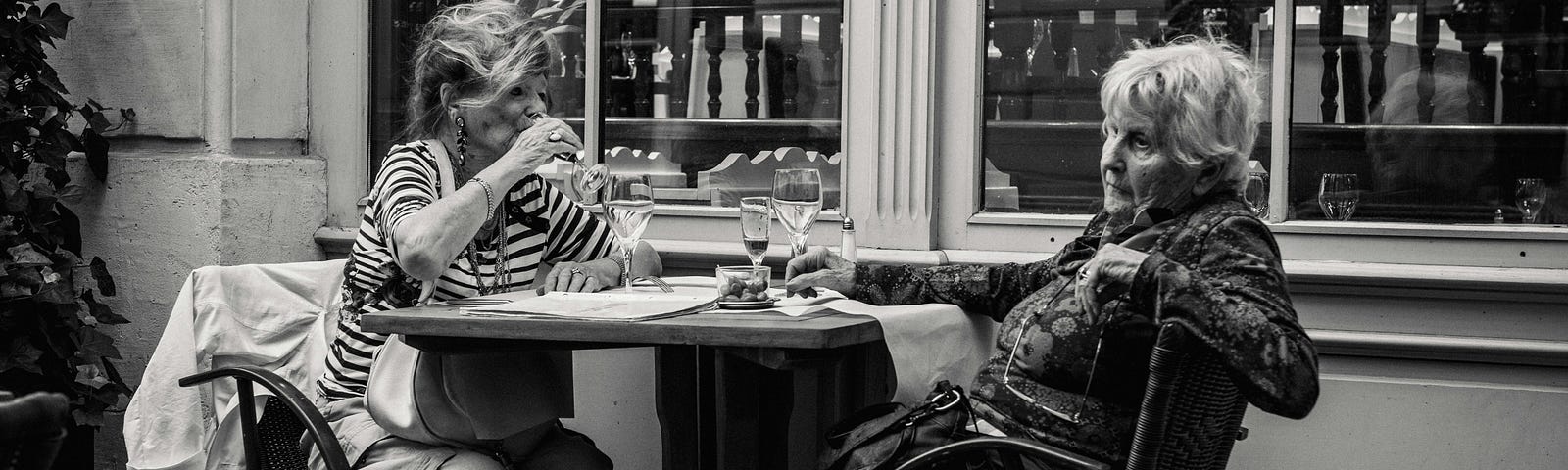 Photo of Elderly Women Sipping Wine on a Patio Outside an Establishment by Jez Timms on Unsplash