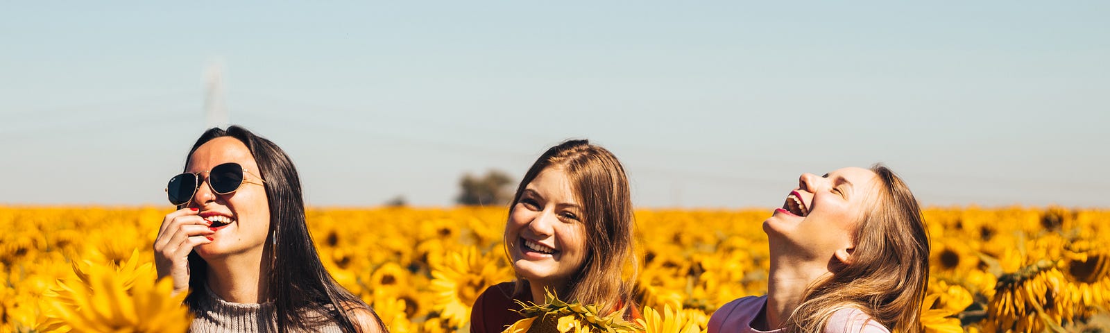 women happy standing in sunflower field