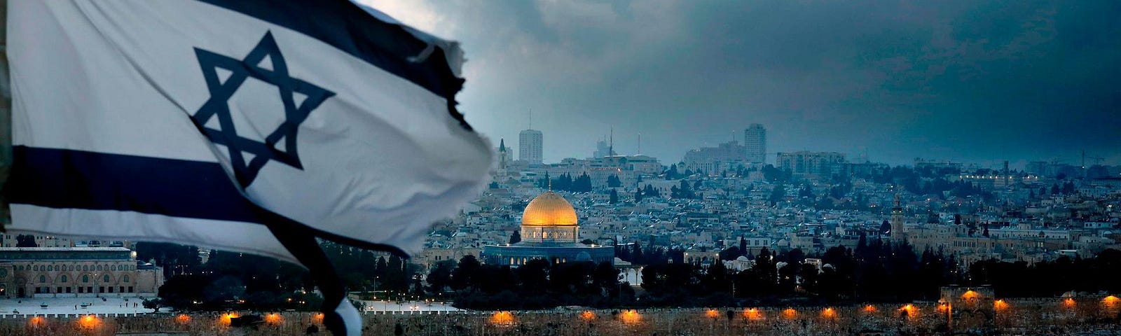 Una bandera israelí ondea en el Monte de los Olivos con la Ciudad Vieja de Jerusalén y la Cúpula de la Roca al fondo, el 27 de marzo de 2019. (Foto: AFP)