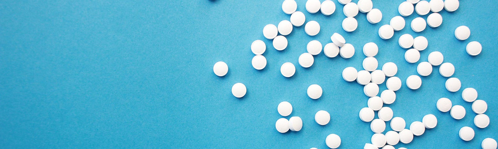 white pills on teal background