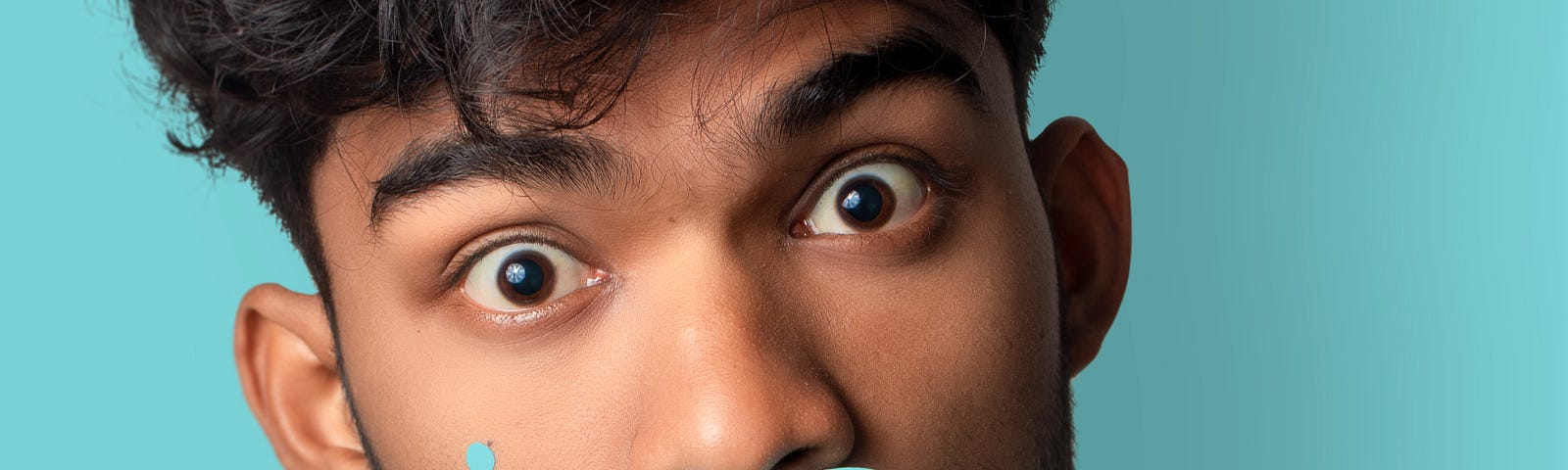 A young man with a fake paper moustache.