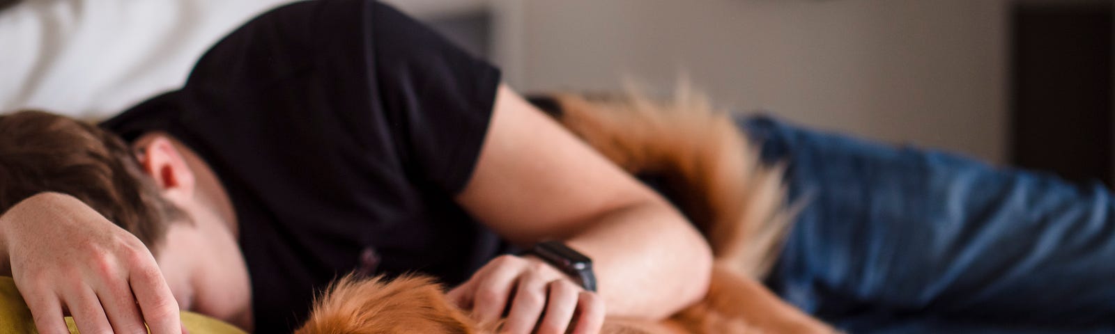 Man asleep with his dog lying next to him.