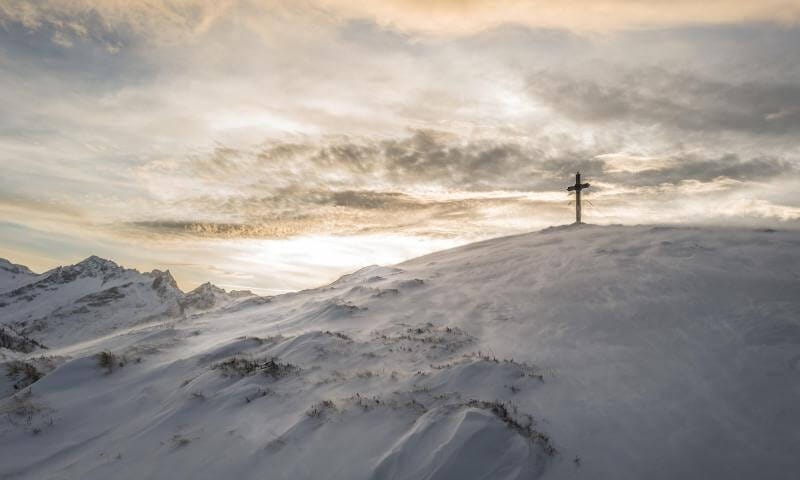 Christian Cross on top of a snow covered mountain
