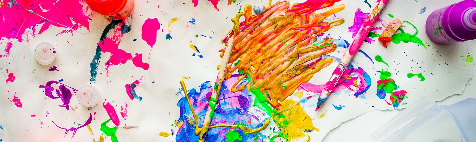 Child painting on a white canvas with bright colored paints