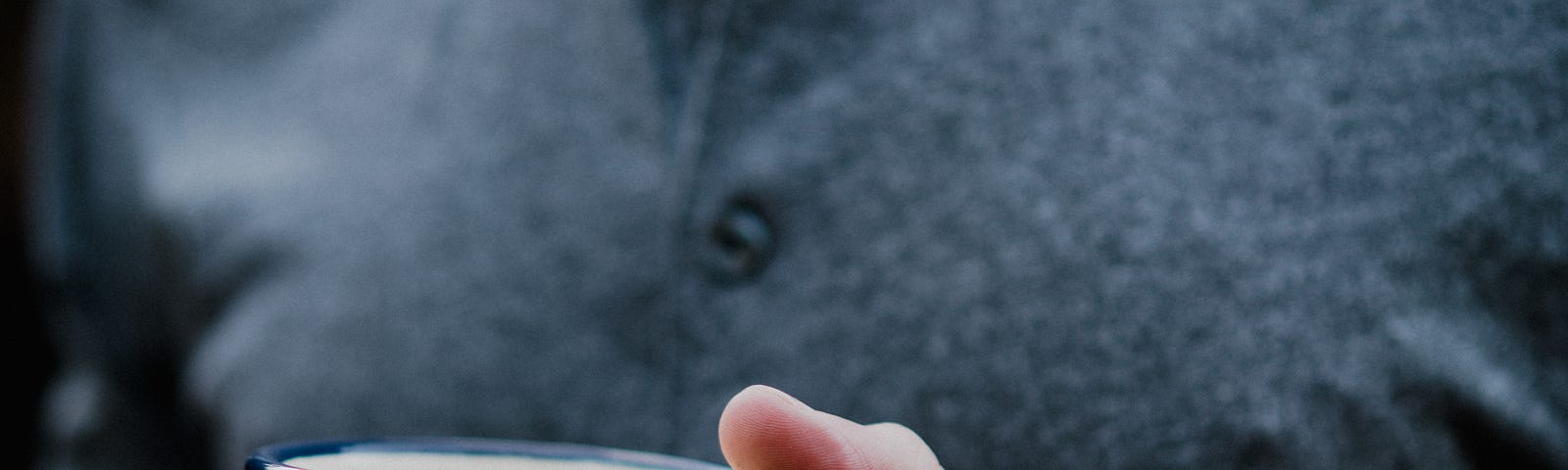 A man holding a coffee cup, I always write with a cup of coffee on hand.