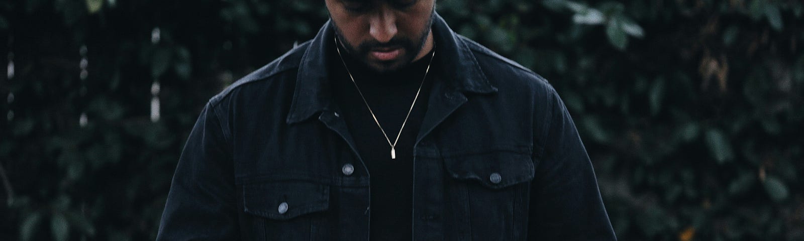 Man in cap and jacket reading Bible