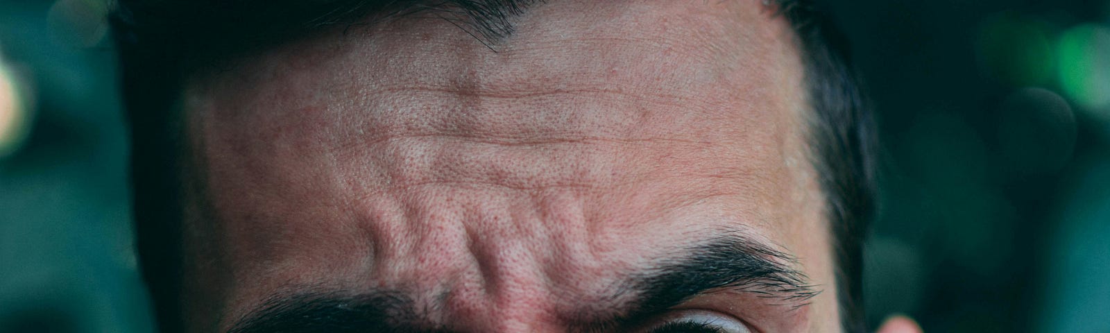 man’s face with wrinkled brow looking out questioning