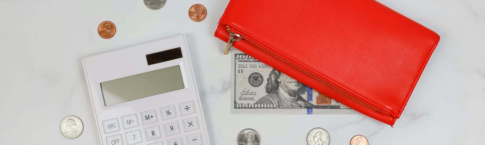 A calculator and some coins with a note partially hidden under a bright orange purse.