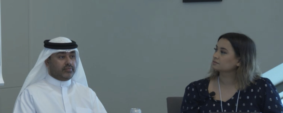 A man and a woman sit at a desk.