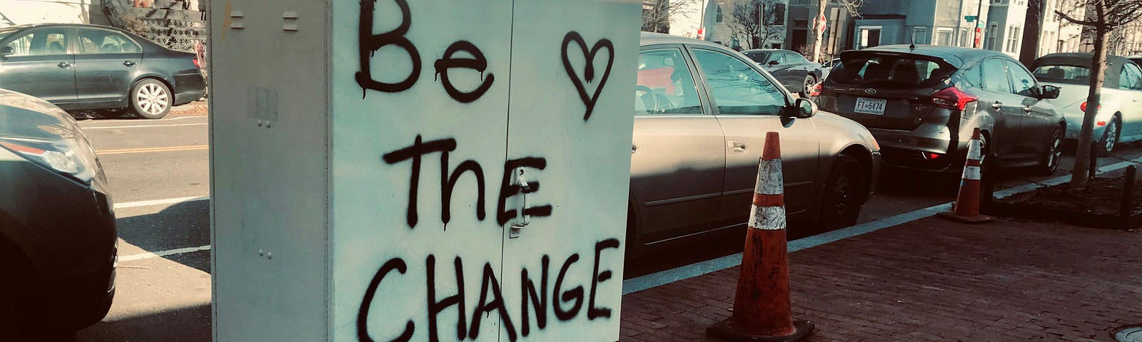 A board that says ‘Be The Change.’