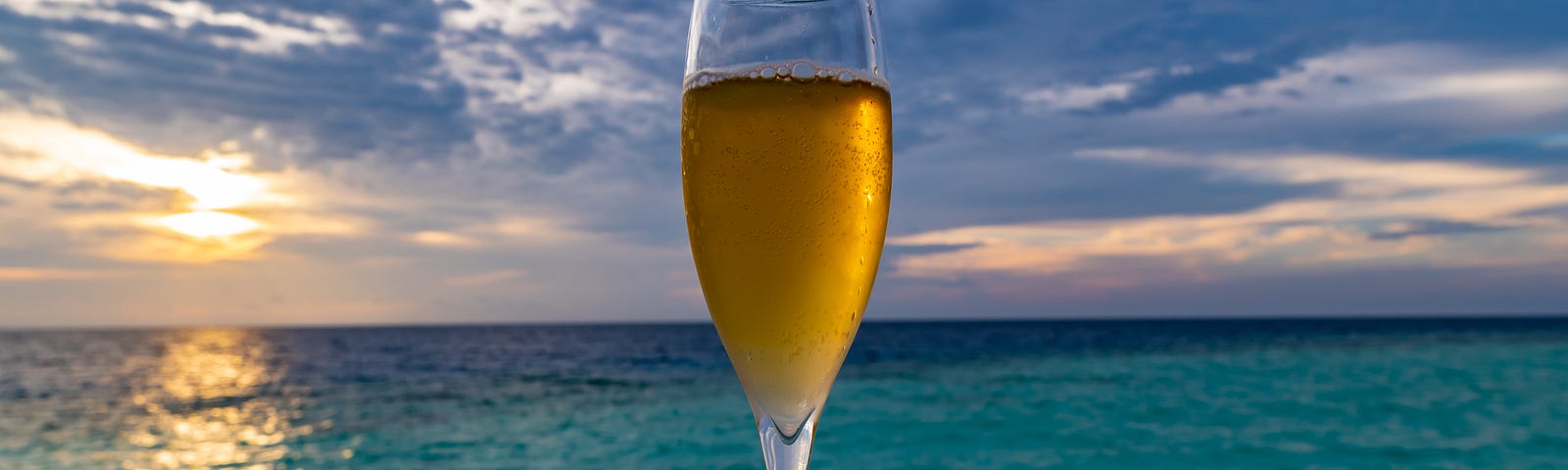 glass of champagne on a dock overlooking the ocean