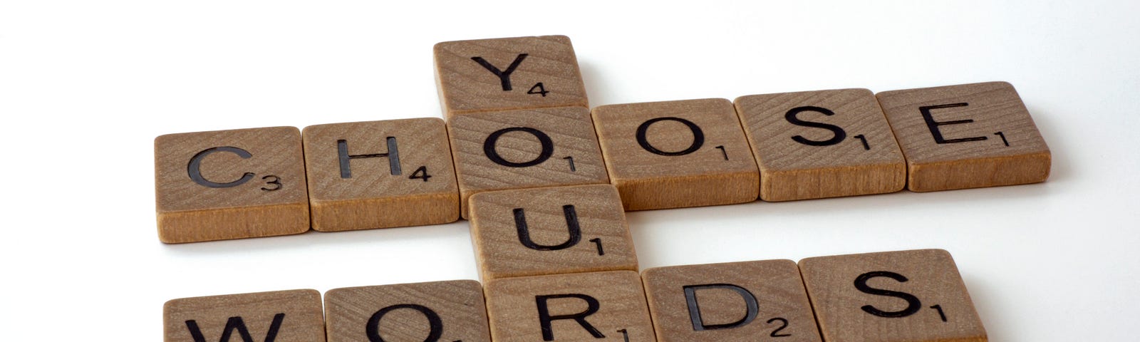 Scrabble tiles spell out “Choose Your Words”.