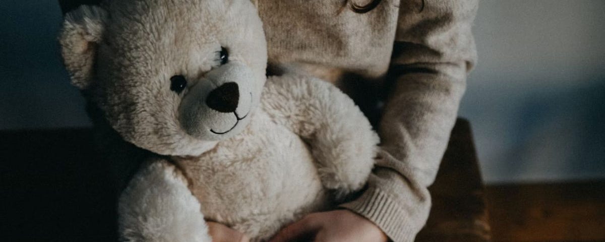 Girl holding bear by Annie Spratt on unsplash