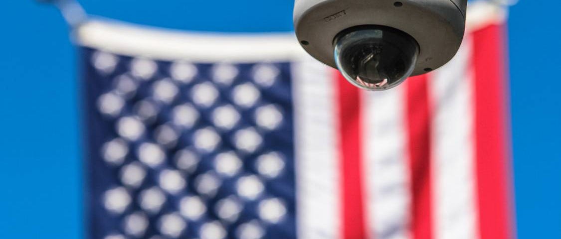 A CCTV camera with the American flag in the background