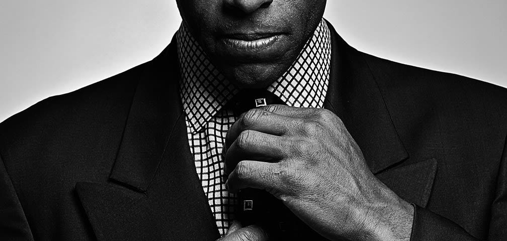 Man straightening his tie and looking out at the viewer